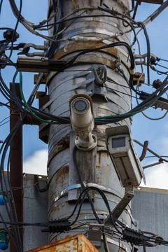 Two old cctv security surveillance cameras on street light pole on blue sky Stock Photos