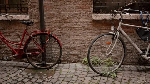 Two old classic bikes red and white parked near ancient brick wall, detail view 库存影片 125712653