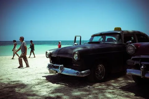 Two old Cuban cabs parked on a beach Stock Photos