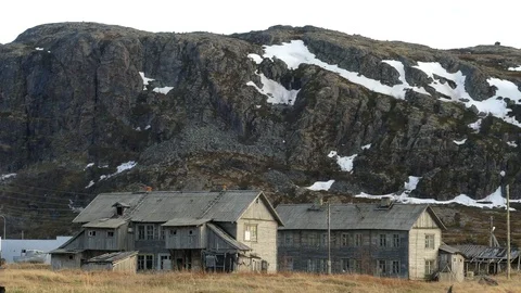 Two old dilapidated house on a background of the rocky mountains. Stock Footage 81726416