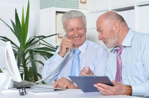 Two old elderly businessmen working in office Stock Photos