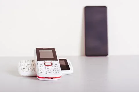 Two old-fashioned white push-button telephones lie on the table on the back.. Stock Photos