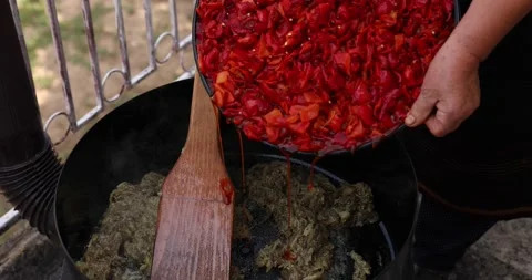 Two old hands stirring chopped pepper in a huge pot while preparing ajvar. Close Video stock 207715549