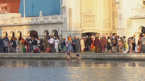 Two Old Indian Men Bathing and Praying in Holy Pool of Water at Golden Temple Stock Footage 129403384