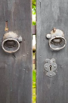 Two old iron ring handles on a door standing ajar Stock Photos