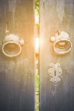 Two old iron ring handles on a door standing ajar Stock Photos