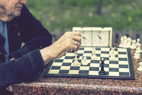 Two old men playing chess. Active retired people, old friends and free time Stock Photos