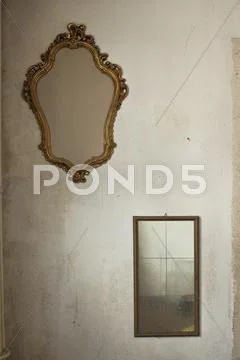 Two Old Mirrors Hanging On Bare Wall