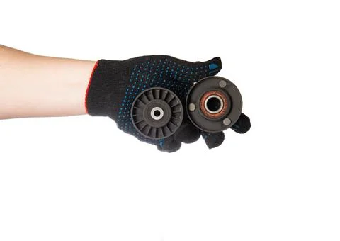 Two old rollers of the timing system from the car in the hand of a car mechanic Stock Photos