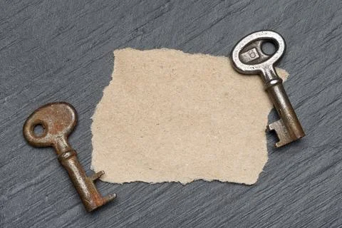 Two old rusty keys and piece of brown paper Stock Photos
