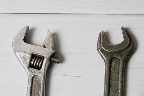 Two old wrenches, adjustable spanner and spanners, on light wooden background Stock Photos