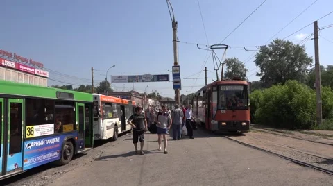 Two oncoming orange trams cross at a stop in Motovilikha borough Stock Footage 64638842