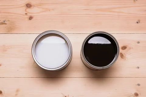 Two open cans with different wood coatings, light and dark, stand side by sid Stock Photos