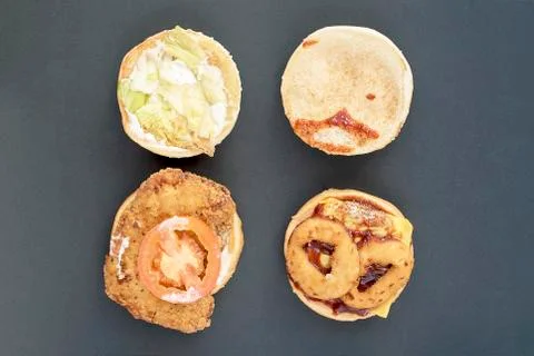 Two open cheeseburger with chicken, tomato, cheese and salad on a dark backgr Stock Photos