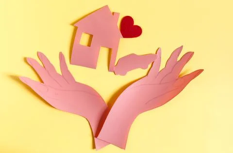 Two open palms made of red paper on a bright yellow background of kopi space. Stock Photos