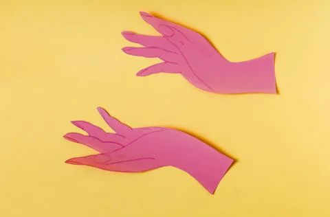 Two open palms made of red paper on a bright yellow background Stock Photos
