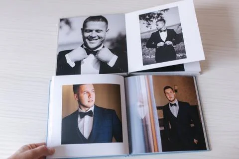 Two open photobook with groom on white wooden table. Comparison Stock Photos