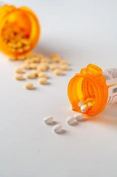 Two open pill bottles with partial label showing Stock Photos