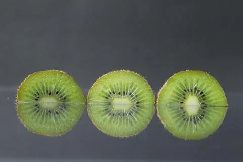 Two or three circles of green kiwi semicircle with a black glossy still life Stock Photos