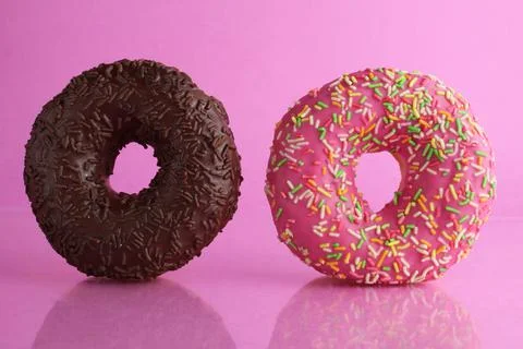 Two or three doughnut berliner pink yellow chocolate on a pink background sta Stock Photos
