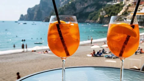 Two orange cocktails on a beachside table with sea and sunset beach Stock Footage 318859444