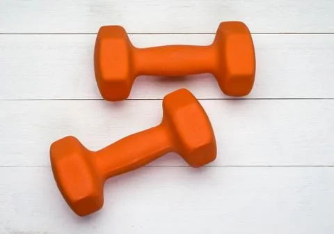 Two orange dumbbells Stock Photos