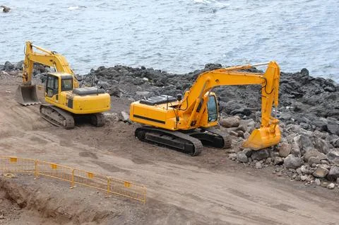 Two orange excavators Stock Photos