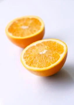 Two orange halves on a light surface. Stock Photos