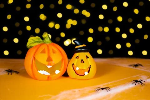 Two orange pumpkins on black background and warm light background. Halloween Stock Photos