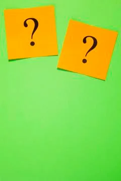 Two orange question marks on green background vertical Stock Photos