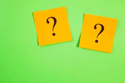 Two orange question marks on green background Stock Photos
