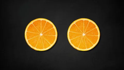 Two orange slices rotating on black board background - animation Stock Footage 109196813