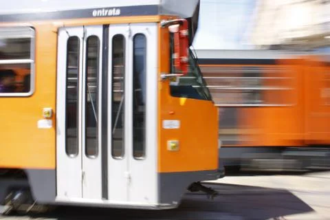 Two orange tram wagon cable cars in high speed crossing each other Stock Photos