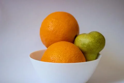 Two oranges and one pear on a white isolated background Stock Photos