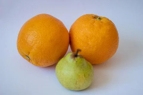 Two oranges and one pear on a white isolated background Stock Photos