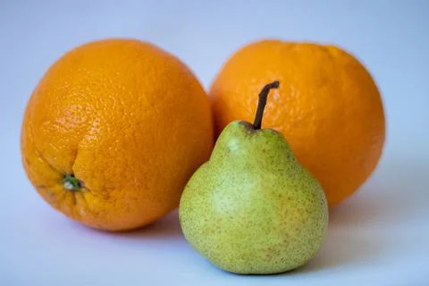 Two oranges and one pear on a white isolated background Stock Photos