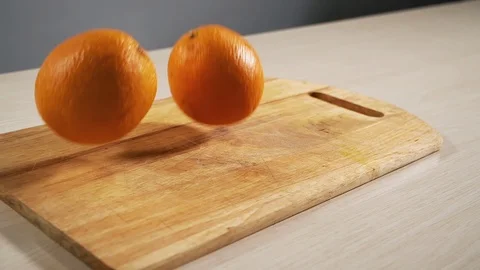 Two oranges drop on the cooking table in slow motion and bounce close-up Stock Footage 118976696