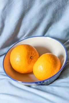 Two oranges fruit on a white ceramic bowl. Stock Photos