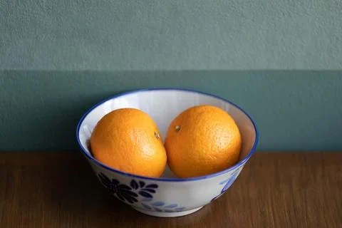Two oranges fruit on a white ceramic bowl. Stock Photos