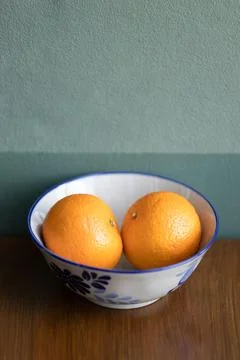 Two oranges fruit on a white ceramic bowl. Stock Photos