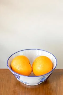 Two oranges fruit on a white ceramic bowl. Stock Photos