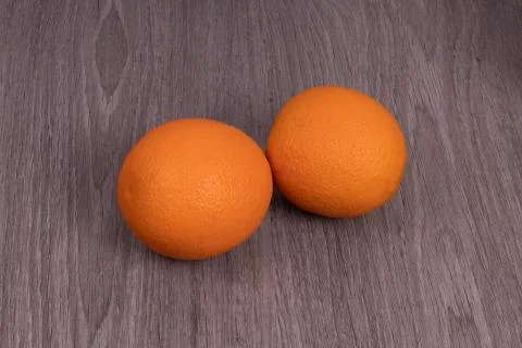 Two oranges located side by side with a wood structure Stock Photos