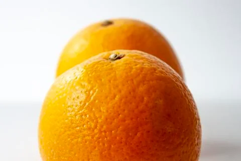 Two oranges placed behind each other isolated on white background. Shallow do Stock Photos