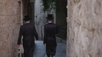 Two Orthodox Jews walk down alleyway in the Old city, Jerusalem, Israel Stock Footage 86038767