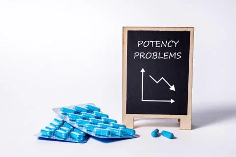 Two packs of blue capsules and the word Potency problems on a chalkboard. Pills Stock Photos