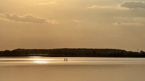 Two Paddleboarders Crossing Lacul Morii Into Golden Sunset Reflection Stock Footage 346380108
