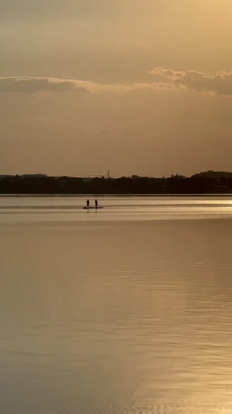 Two Paddleboarders Silhouetted Against Sunset on Lacul Morii Stock Footage 346380104