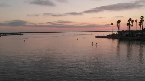 Two Paddleboarders at sunset on Oceanside Harbor Stock Footage 129737313