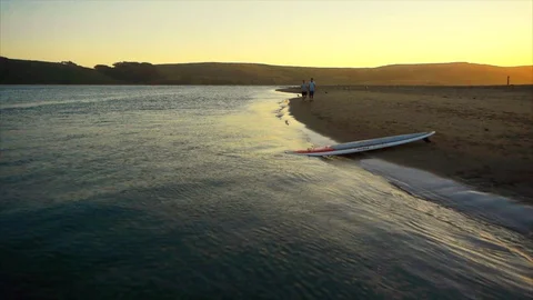 Two paddleboarding walking along the beach together. 스톡 동영상 88368296