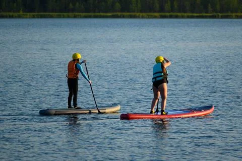 Two on Paddleboards Float on Lake in Bright Day Stock Photos